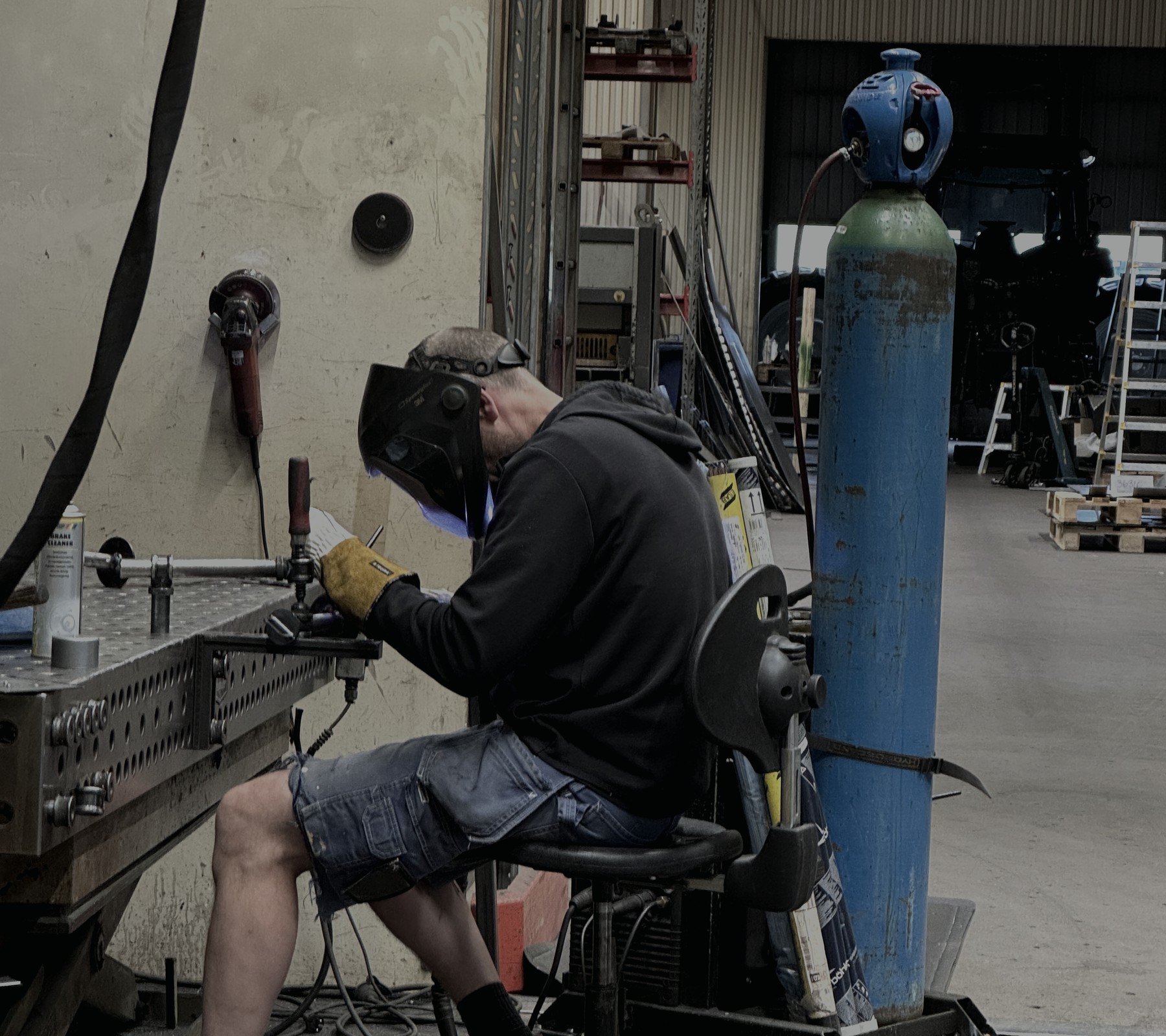 Welder fabricating a metal assembly in the REDMARK workshop